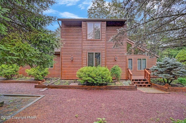 back of property with a wooden deck and a patio