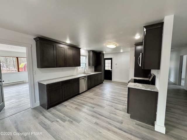 kitchen featuring baseboards, light wood-style flooring, stainless steel appliances, a baseboard heating unit, and a sink