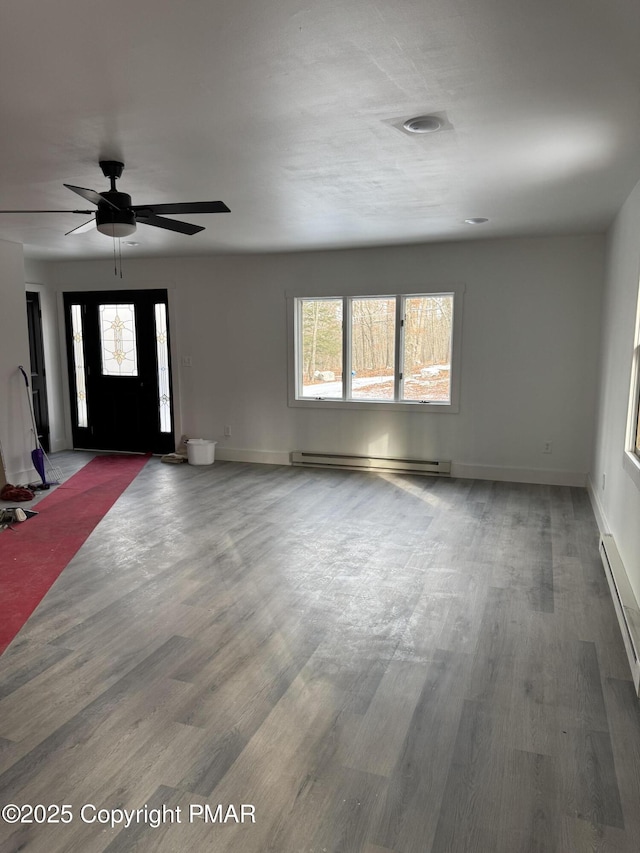 foyer entrance with baseboards, ceiling fan, wood finished floors, baseboard heating, and a baseboard heating unit