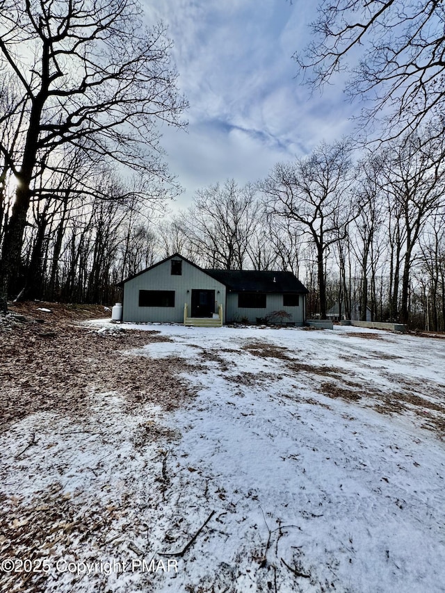 snow covered structure with an outbuilding