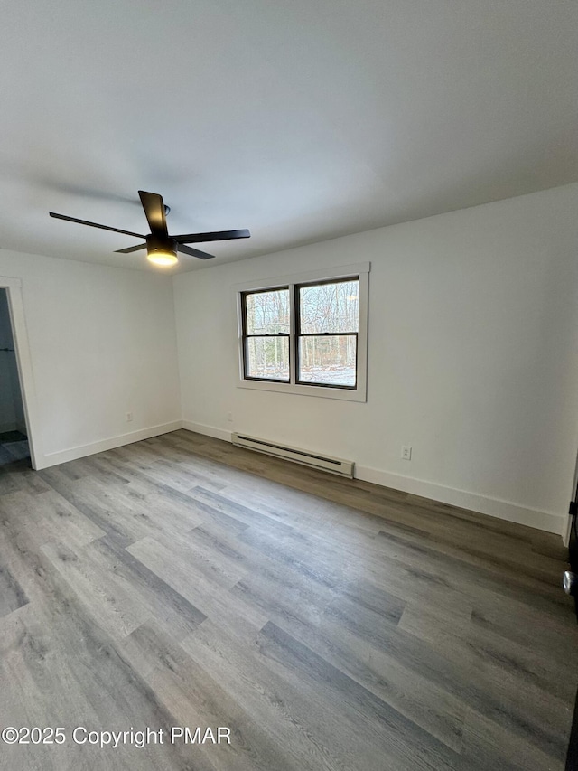 unfurnished room with a baseboard radiator, ceiling fan, baseboards, and wood finished floors