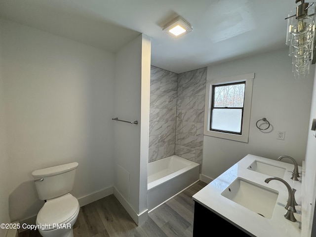 bathroom with toilet, baseboards, a sink, and wood finished floors