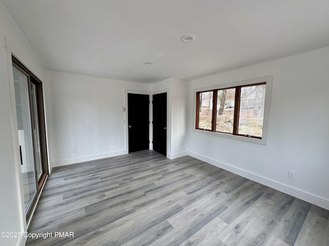 unfurnished room featuring baseboards and wood finished floors