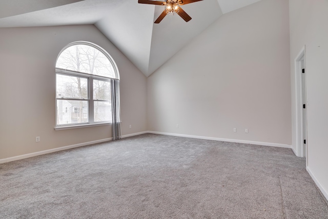 empty room with lofted ceiling, ceiling fan, carpet floors, and baseboards