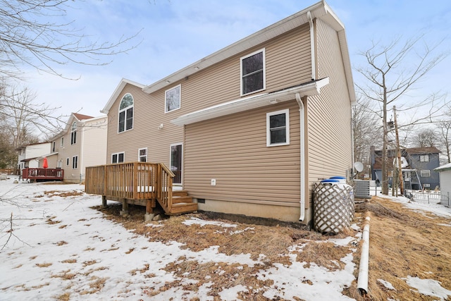 snow covered back of property featuring a residential view and a deck