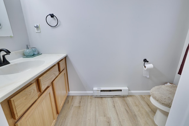 half bath featuring a baseboard radiator, baseboards, toilet, and wood finished floors