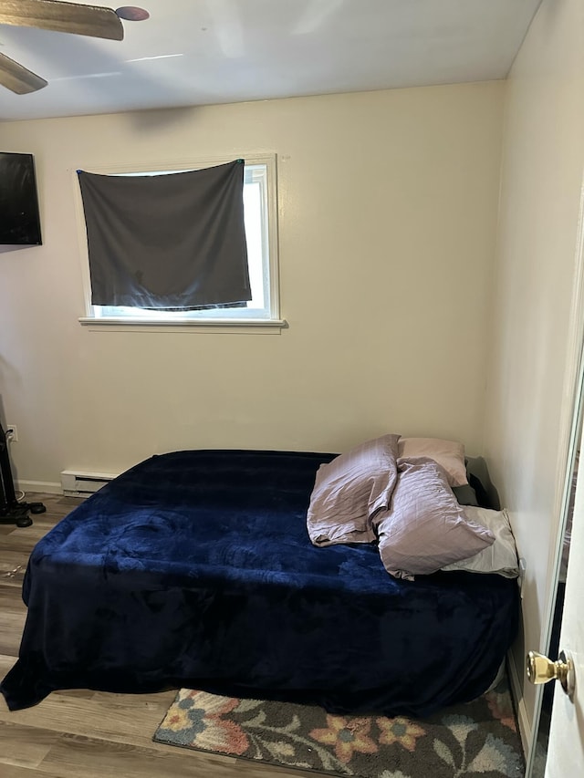 1010 Knollwood Dr, Tobyhanna, PA 18466 - bedroom featuring baseboard heating, wood finished floors, baseboards, and ceiling fan