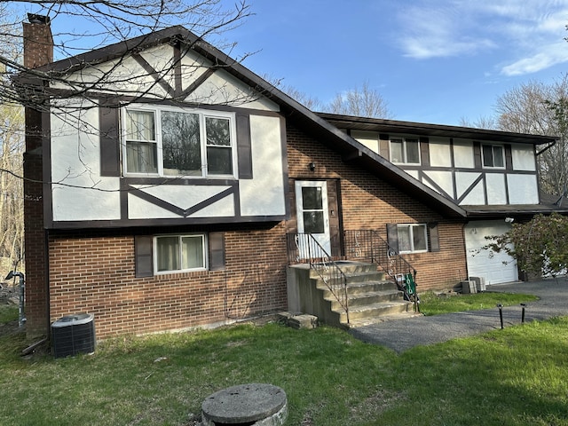 1010 Knollwood Dr, Tobyhanna, PA 18466 - view of front of property with brick siding, a chimney, central air condition unit, a front lawn, and stucco siding
