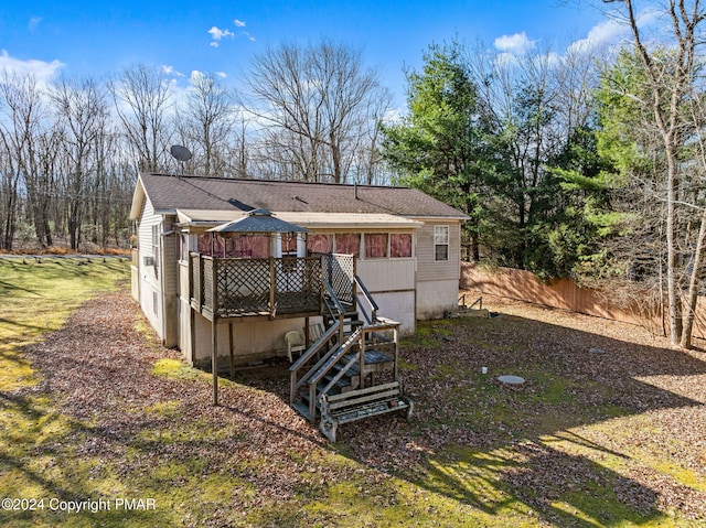 back of property featuring stairway, a shingled roof, fence, and a deck