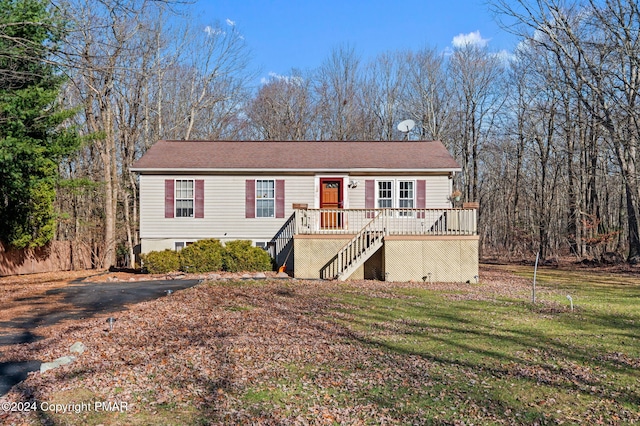 view of front facade with stairs, a deck, and a front yard