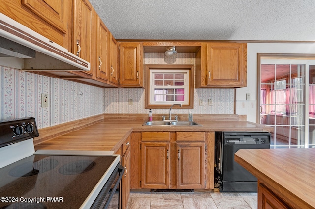 kitchen with black appliances, wallpapered walls, a sink, and a textured ceiling