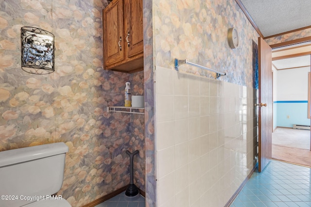 bathroom featuring a baseboard heating unit, tile patterned flooring, a textured ceiling, and wallpapered walls