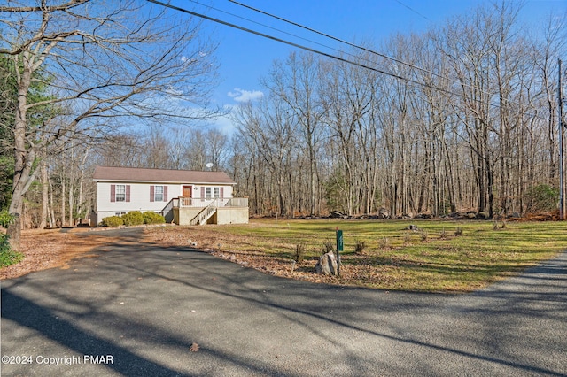 view of front of property featuring driveway, stairway, and a front yard