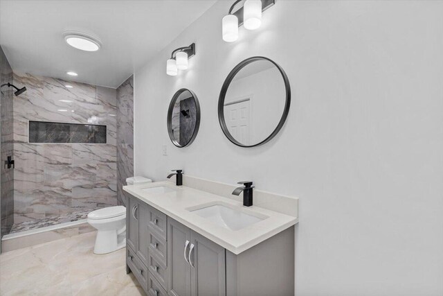 bathroom with toilet, a marble finish shower, a sink, and marble finish floor