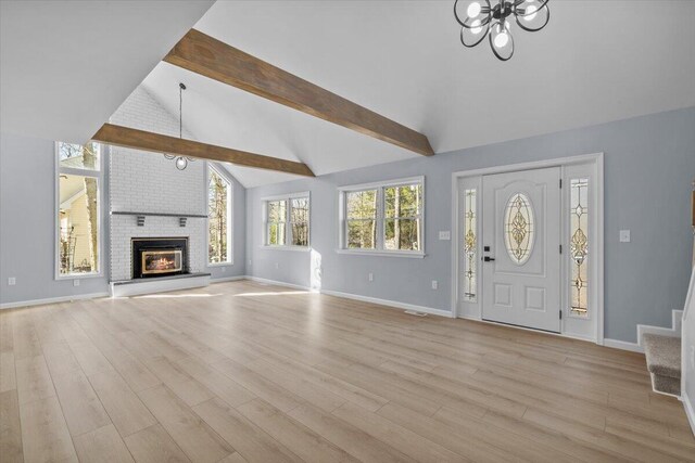 entrance foyer with baseboards, a notable chandelier, vaulted ceiling with beams, and light wood finished floors