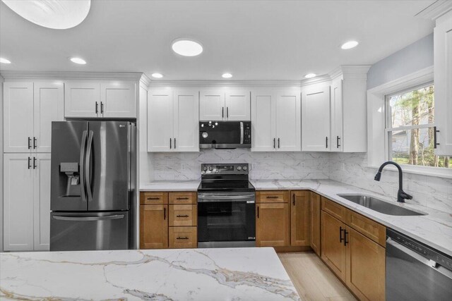 kitchen with white cabinets, stainless steel appliances, decorative backsplash, and a sink