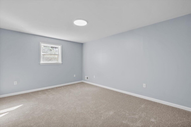 unfurnished room with carpet flooring and baseboards
