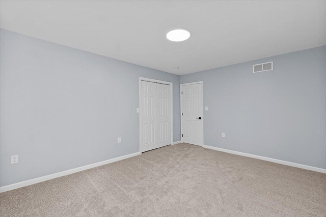 spare room featuring carpet flooring, baseboards, and visible vents