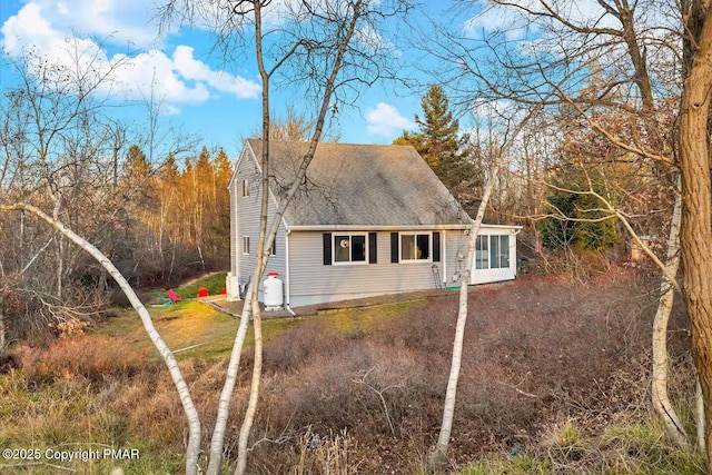 view of home's exterior featuring driveway and a shingled roof