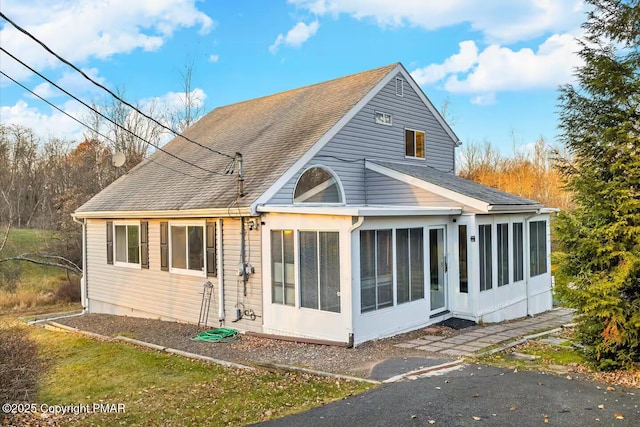 rear view of house featuring a sunroom