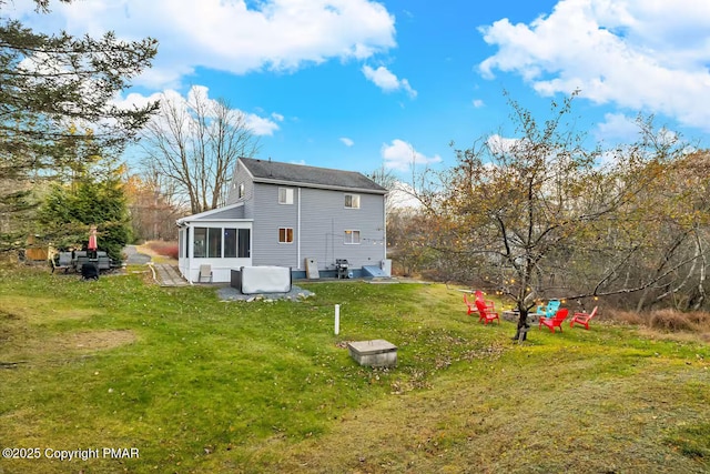 rear view of property with a yard and a sunroom