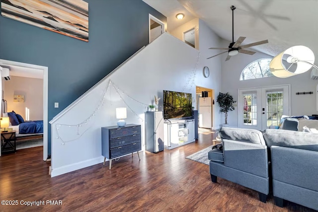 living area with ceiling fan, high vaulted ceiling, wood finished floors, baseboards, and french doors