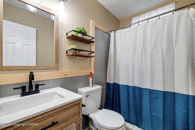 bathroom featuring vanity, tile walls, and toilet