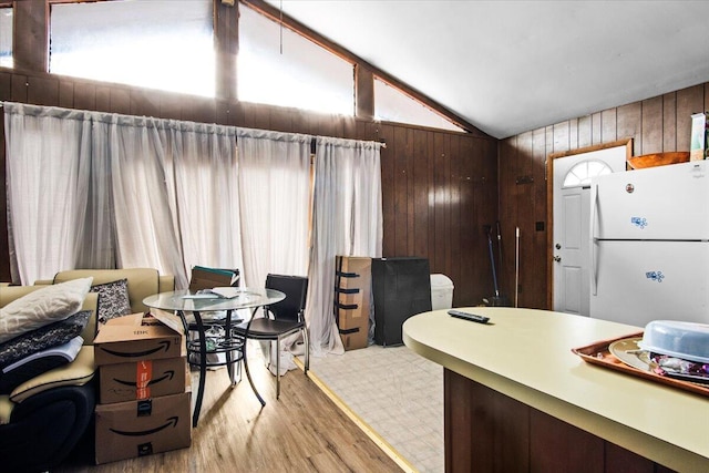 8062 Red Squirrel Dr, Tobyhanna, PA 18466 - kitchen featuring freestanding refrigerator, vaulted ceiling, wooden walls, and light wood finished floors