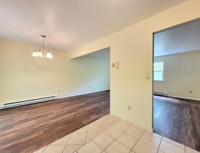 1169 Hunters Woods Dr, East Stroudsburg, PA 18301 - spare room with wood finished floors, a baseboard heating unit, and a chandelier