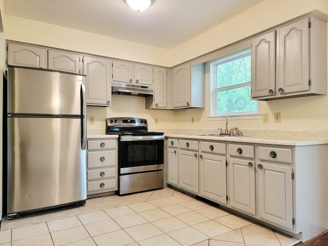 1169 Hunters Woods Dr, East Stroudsburg, PA 18301 - kitchen with appliances with stainless steel finishes, under cabinet range hood, a sink, light countertops, and light tile patterned floors