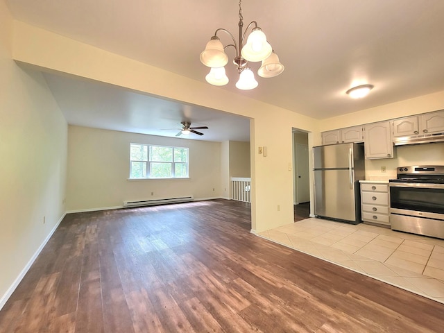 1169 Hunters Woods Dr, East Stroudsburg, PA 18301 - kitchen with appliances with stainless steel finishes, under cabinet range hood, a baseboard heating unit, wood finished floors, and a chandelier