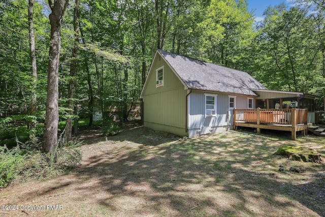 back of house featuring a deck, roof with shingles, cooling unit, and a view of trees