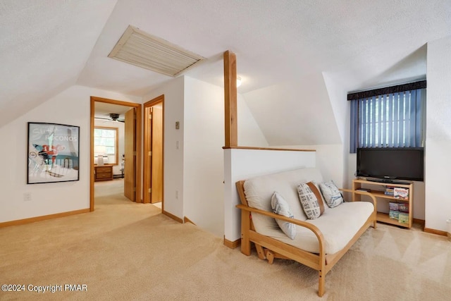 living area with a textured ceiling, carpet flooring, lofted ceiling, and visible vents