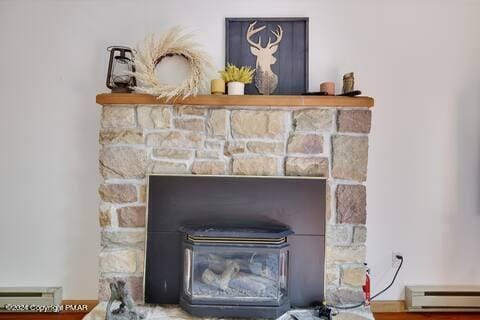 details with a baseboard radiator and a wood stove