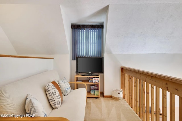 living room featuring vaulted ceiling, carpet flooring, and baseboards