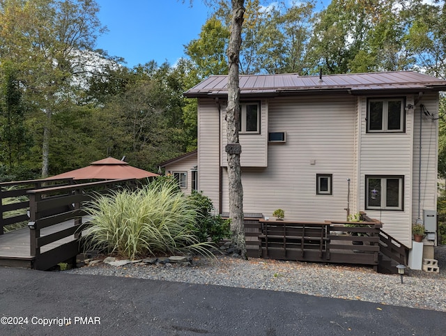 view of front of house with a standing seam roof, a wooden deck, and metal roof