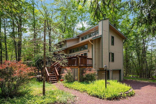 4169 Hemlock Trl, Pocono Pines, PA 18350 - rear view of property with an attached garage, stairs, driveway, a deck, and a chimney
