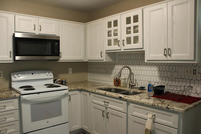 5147 Arrowhead Ln, East Stroudsburg, PA 18302 - kitchen with stainless steel microwave, white electric stove, tasteful backsplash, and white cabinets