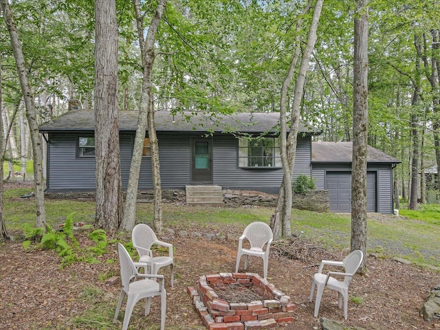275 Selig Rd, Pocono Lake, PA 18347 - rear view of house with a fire pit, a garage, a shingled roof, and entry steps