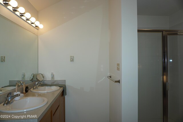 bathroom featuring a sink, double vanity, and a shower stall