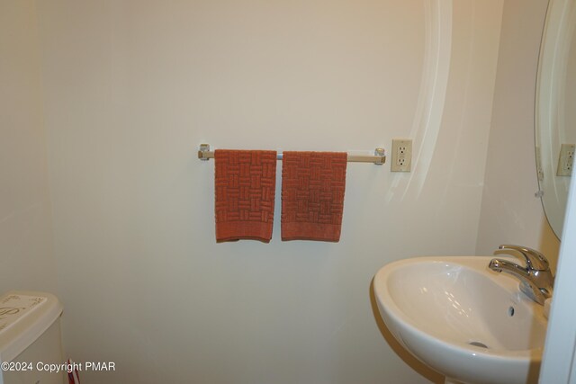 bathroom with a garden tub, toilet, and vaulted ceiling