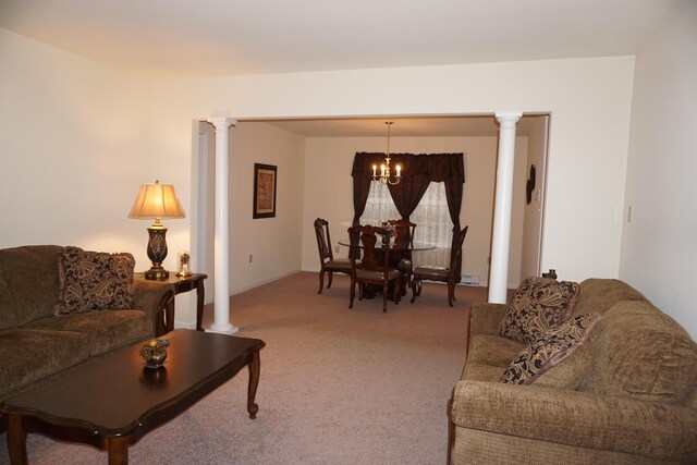 living area featuring decorative columns and light carpet