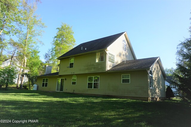 rear view of property with a yard and a chimney