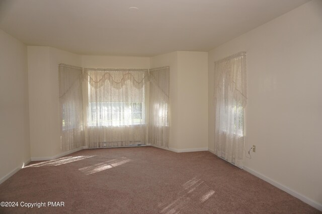 carpeted spare room with baseboards