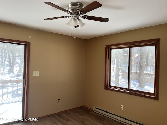 spare room featuring ceiling fan, baseboards, baseboard heating, and dark wood-style floors