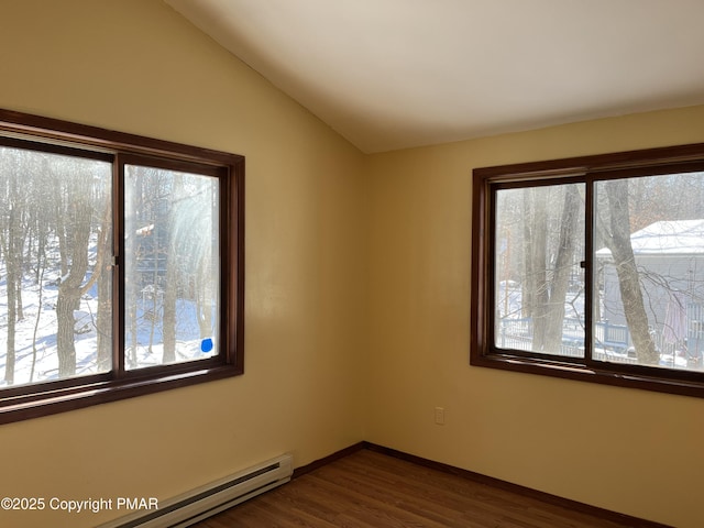 empty room featuring a baseboard heating unit, baseboards, dark wood-style floors, and vaulted ceiling