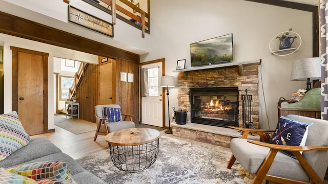 living room with a fireplace, stairs, and wood finished floors