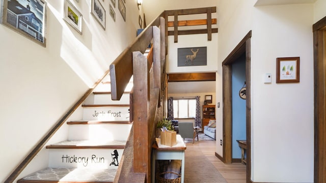 staircase featuring a high ceiling and wood finished floors