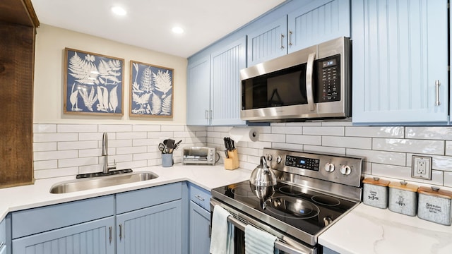 kitchen with tasteful backsplash, recessed lighting, appliances with stainless steel finishes, and a sink