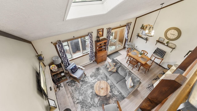 living area featuring lofted ceiling, a textured ceiling, and wood finished floors